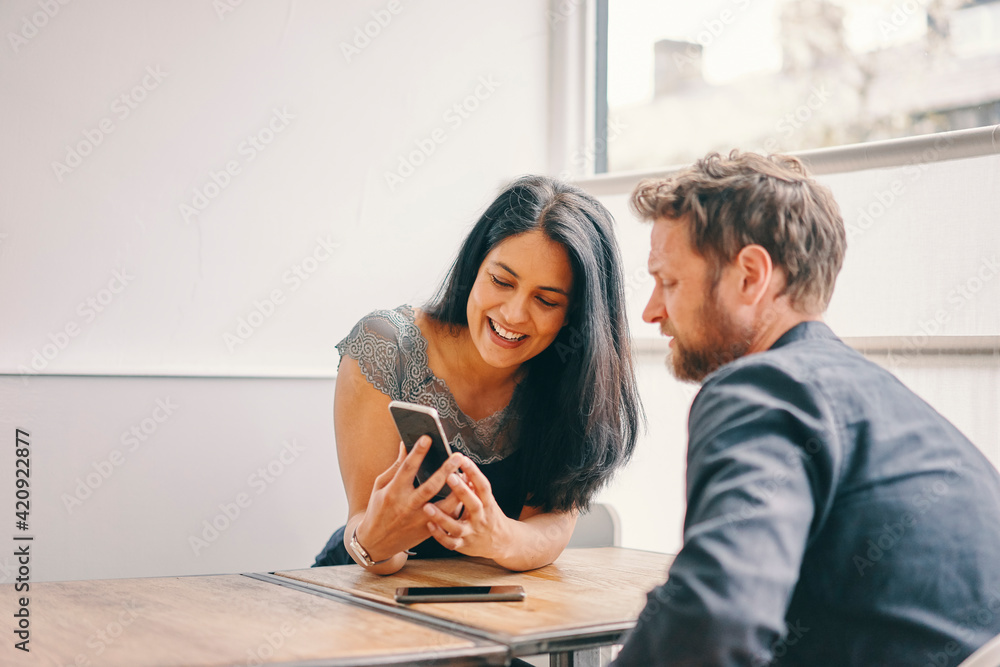 Couple talking and using smartphone in restaurant Couple talking and using smartphone in restaurant