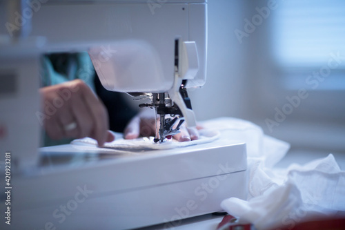 Close up of female tailor using sewing machine. photo