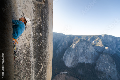 Mountaineer climbing up sheer wall of The Nose, El Capitan, Yosemite National Park. 