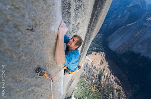 High angle view of mountaineer climbing up sheer wall of The Nose, El Capitan, Yosemite National Park. 