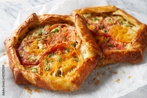 Two individual tomato tarts on a piece of greaseproof paper. photo