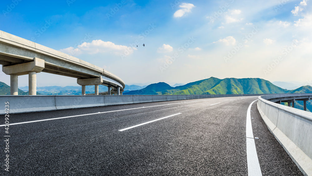 Naklejka premium Asphalt highway and green mountains in summer.