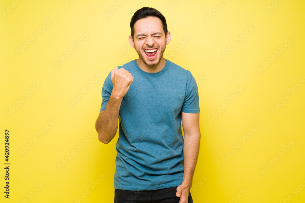 Successful hispanic man cheering for his triumph Successful hispanic man cheering for his triumph