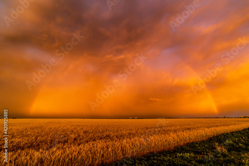 A dust storm with vivid orange sky and rainbow