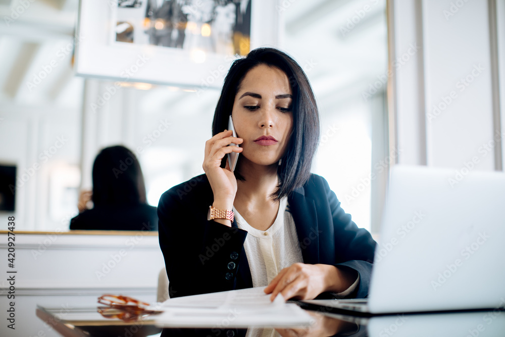 Businesswoman using smartphone and laptop in suite Businesswoman using smartphone and laptop in suite