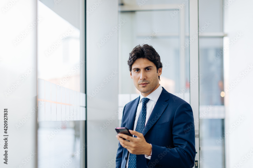 Businessman using smartphone in office building Businessman using smartphone in office building