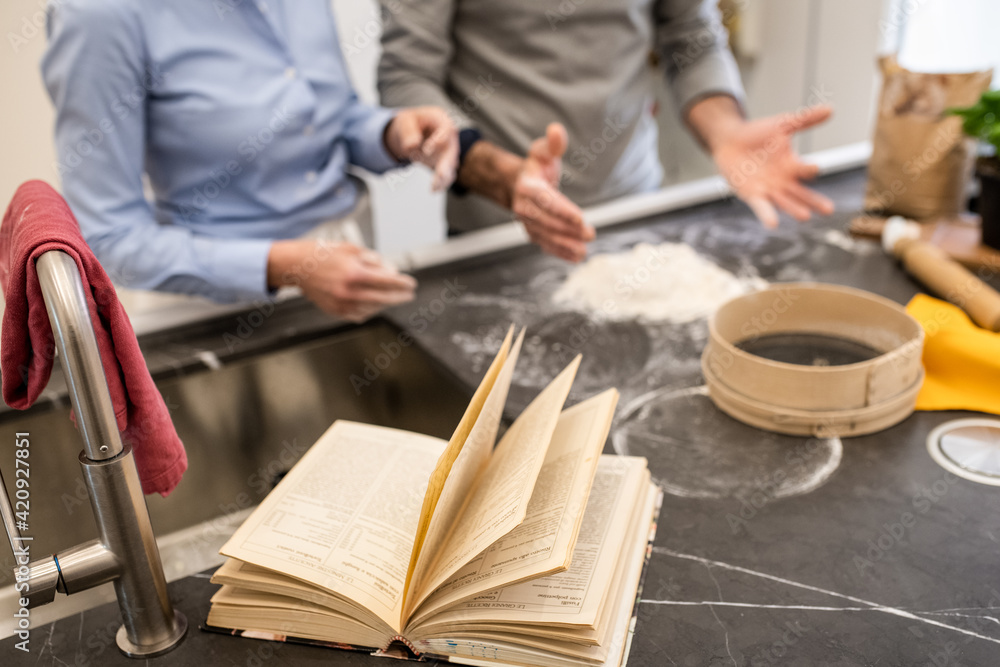 Couple standing in a kitchen, making fresh homemade pasta. Couple standing in a kitchen, making fresh homemade pasta.