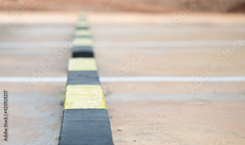 Row of concrete wheel stopper, selective soft focus.