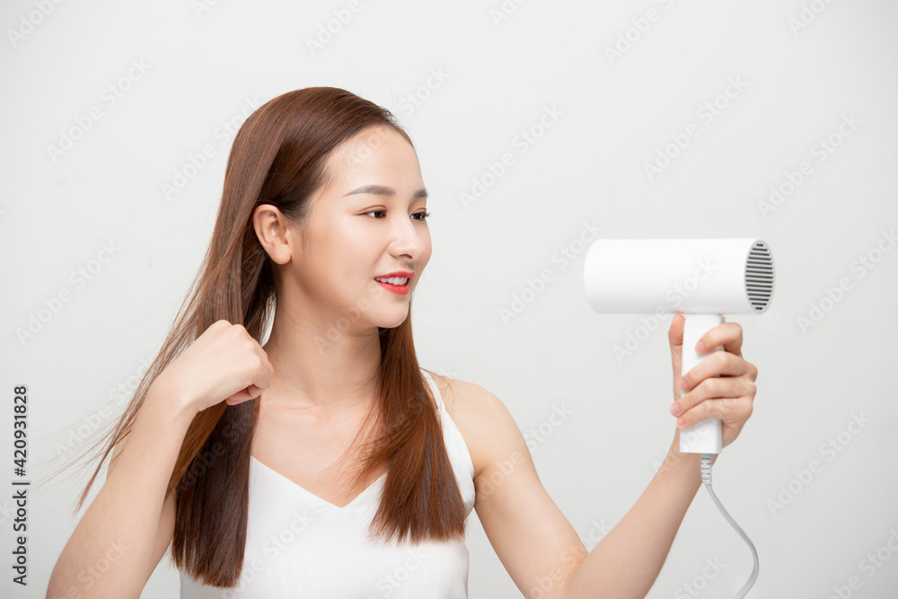 Attractive beautiful Asian woman blowing the wind by hair dryer Attractive beautiful Asian woman blowing the wind by hair dryer