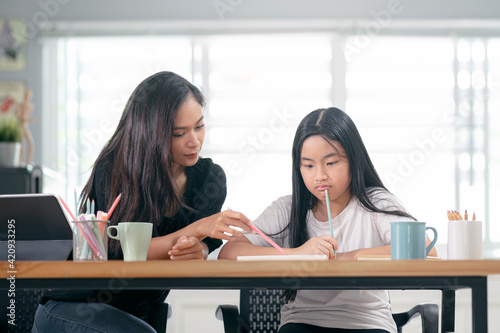 mother and child daughter doing homework together.