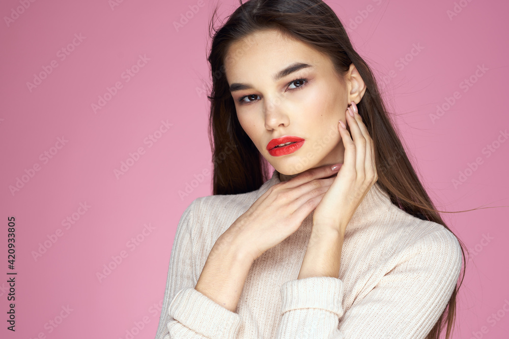 Pretty brunette in a white sweater red lips attractive look pink background Pretty brunette in a white sweater red lips attractive look pink background