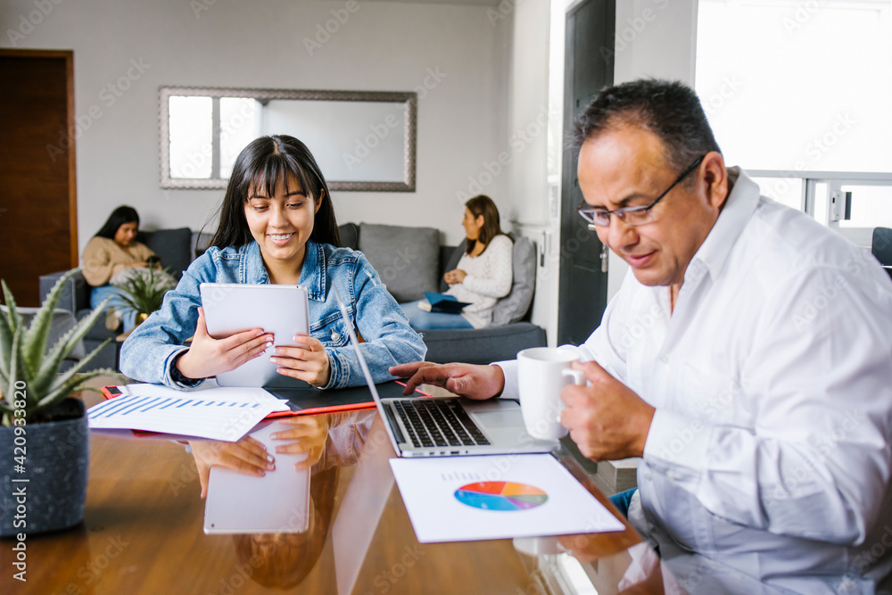 Fototapeta premium hispanic father with daughter at home as the pandemic coronavirus (COVID-19) forces many employees and students to work and study from home in Latin America