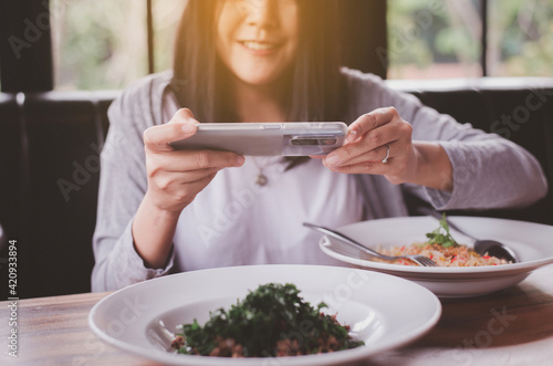 Woman taking a photo food by smartphone in restaurant,Enjoying with meal