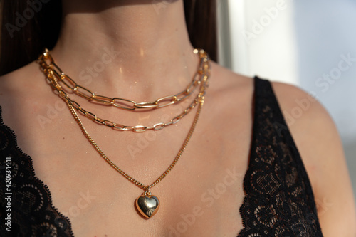 Fototapeta Beautiful model brunette in modern gold metal necklace chain