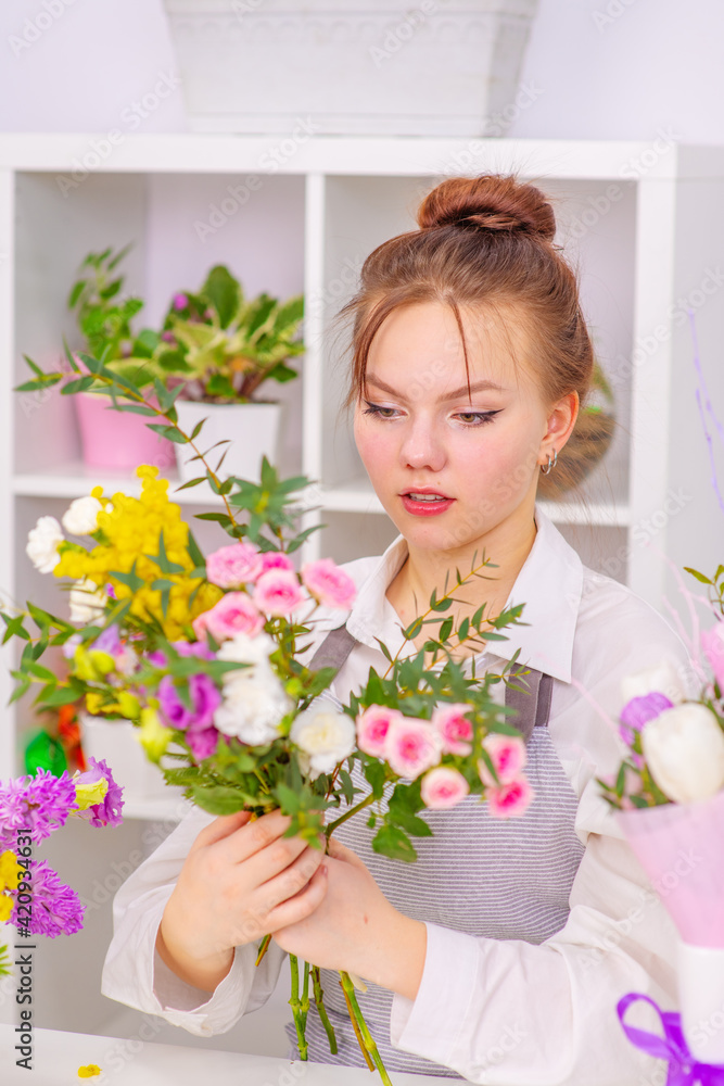 Startup successful small business. Businesswoman owner female standing behind counter with  flowers in floral shop. Girl portrait, successful owner, eco friendly concept .
