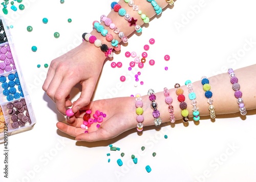 Photographie girl making colorful bead bracelets