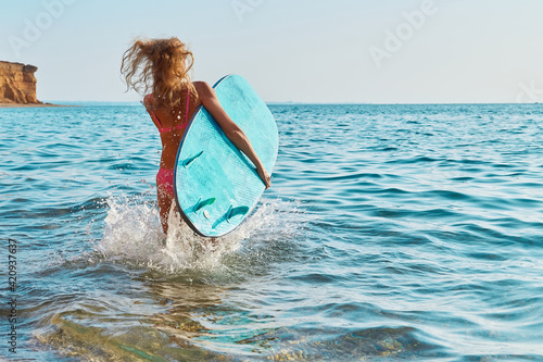 Photography Girl running in sea water with surfboard