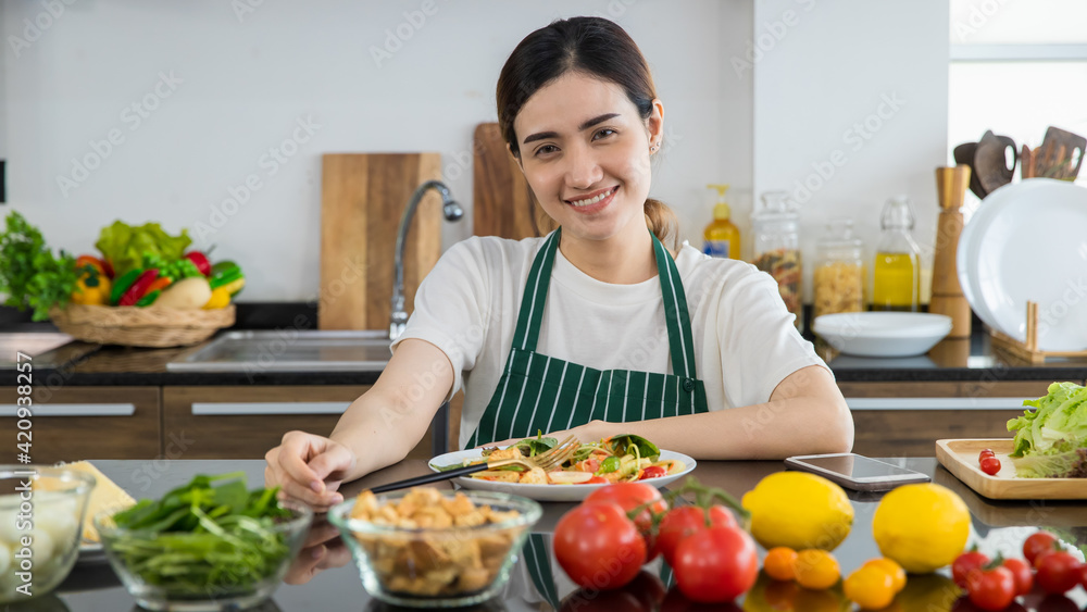 Asian woman having healthy lunch in kitchen