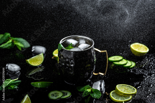 Moscow mule cocktail with lime, mint and cucumber. alcoholic cocktail in copper mugs, freeze motion effect
