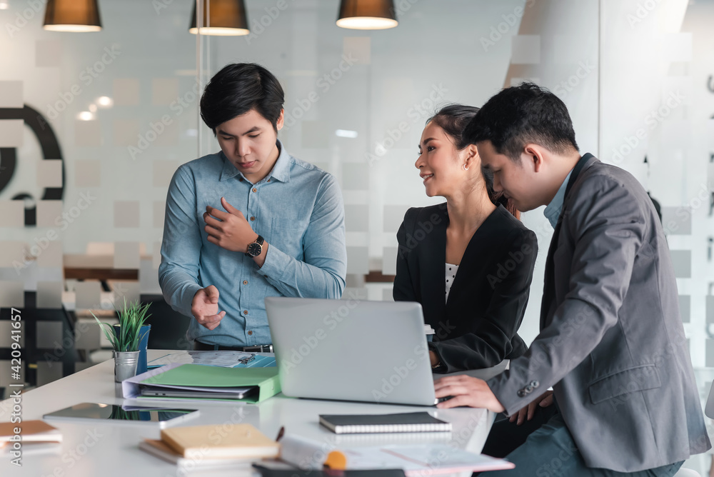 Group of Asian businessman and businesswoman brainstorm for collaborative planning using laptop and documents at the office. Group of Asian businessman and businesswoman brainstorm for collaborative planning using laptop and documents at the office.