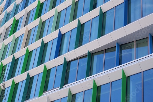 Modern quadratic building detail with windows of blue and green colourshades