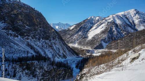 Valley among Sayan Mountains with Frozen Water Surface in Winter. Irkut River Covered with Ice and Snow, Russia