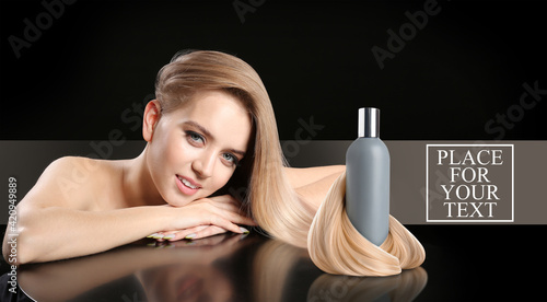 Young blonde with beautiful hair and bottle of shampoo on dark background with space for text