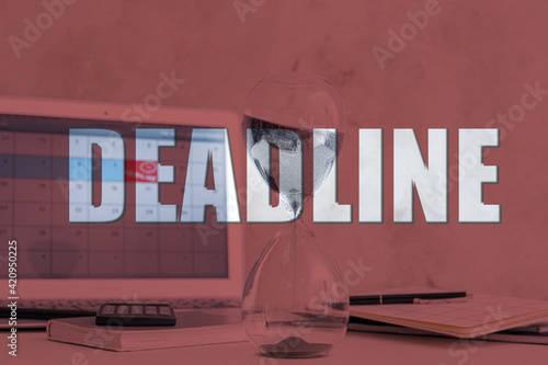 Double exposure of word DEADLINE and hourglass at workplace