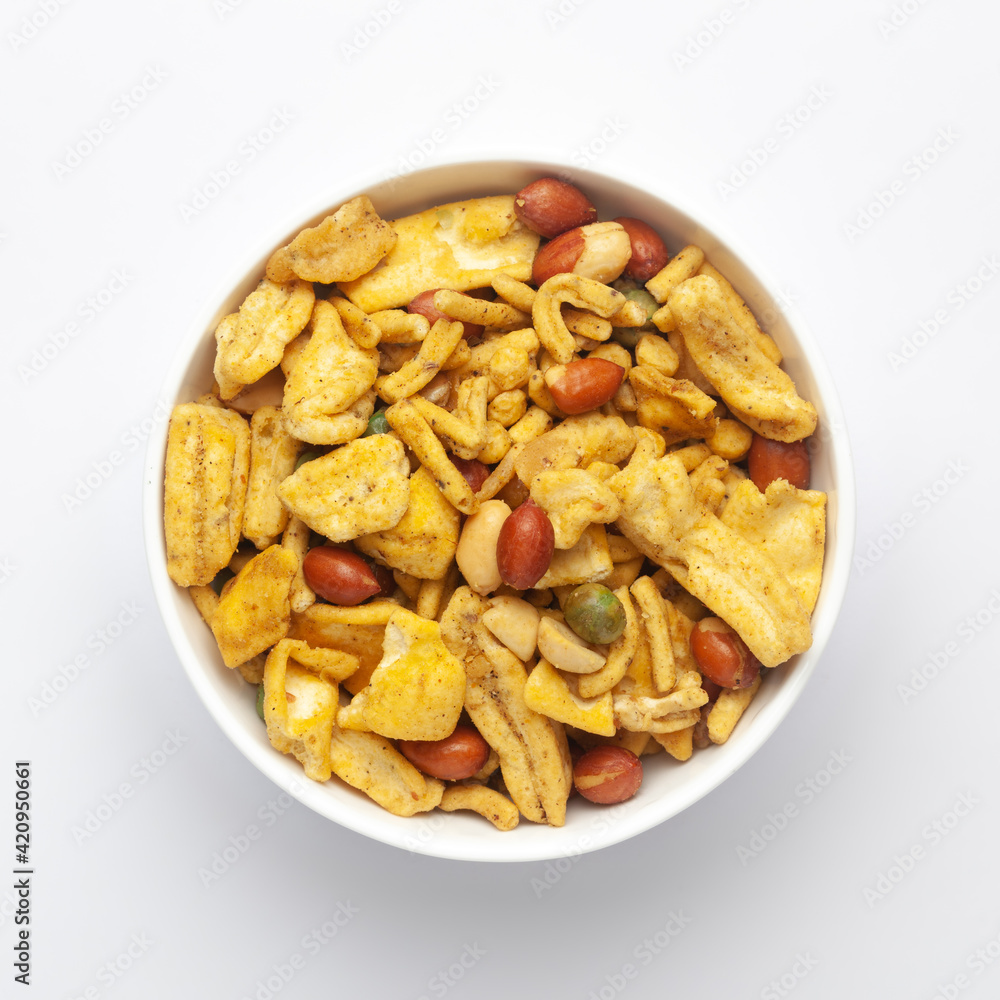 Close up of plane salty Golden Mixture Indian namkeen (snacks) on a ceramic white bowl. Top view Close up of plane salty Golden Mixture Indian namkeen (snacks) on a ceramic white bowl. Top view
