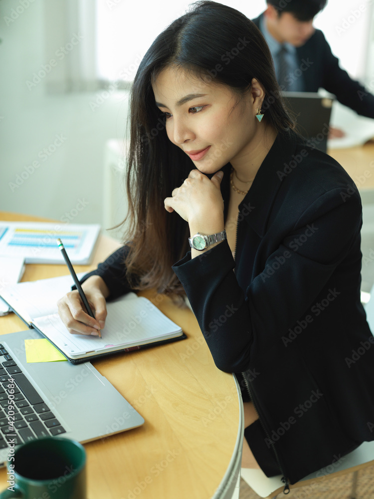 Portrait of businesswoman in black suit concentrating on her work Portrait of businesswoman in black suit concentrating on her work
