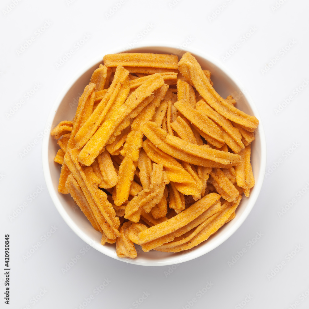 Close up of salted Soya Sticks Indian namkeen (snacks) on a ceramic white bowl. Top view Close up of salted Soya Sticks Indian namkeen (snacks) on a ceramic white bowl. Top view
