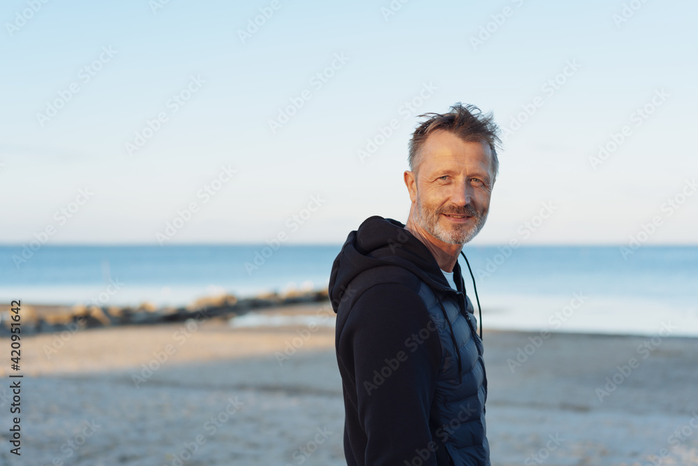 Attractive senior man turning to look thoughtfully at the camera Attractive senior man turning to look thoughtfully at the camera