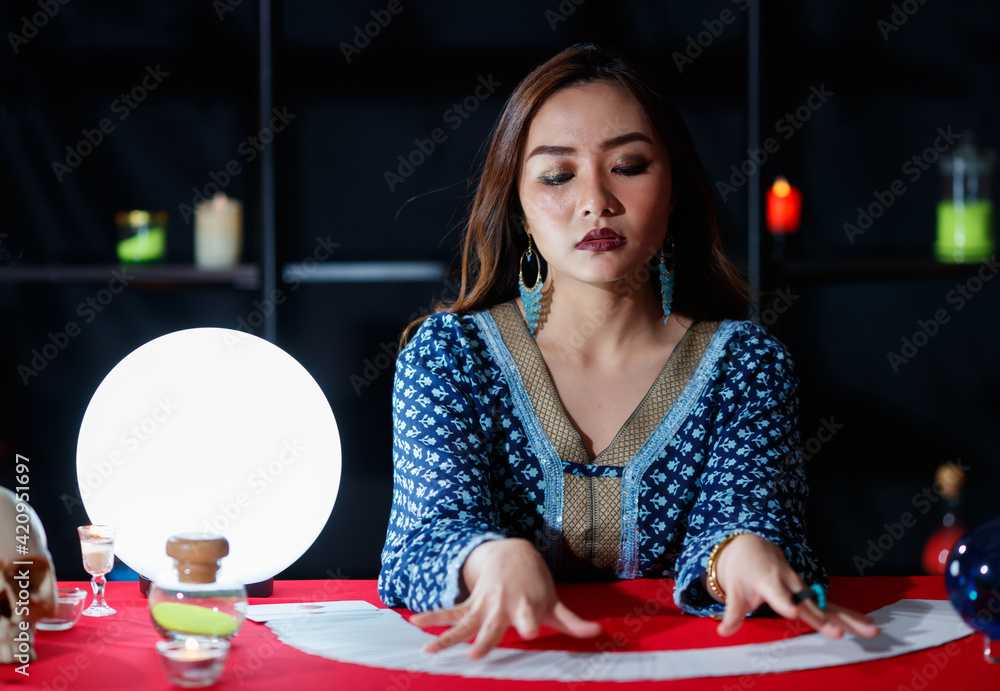 Asian fortune teller reading cards with closed eyes Asian fortune teller reading cards with closed eyes