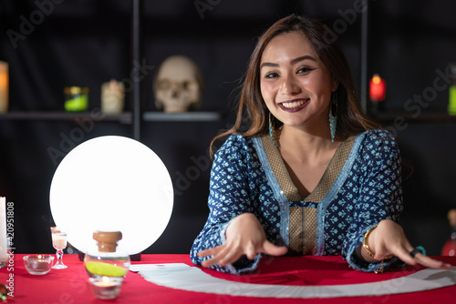 Фотография Asian fortune teller reading cards with closed eyes