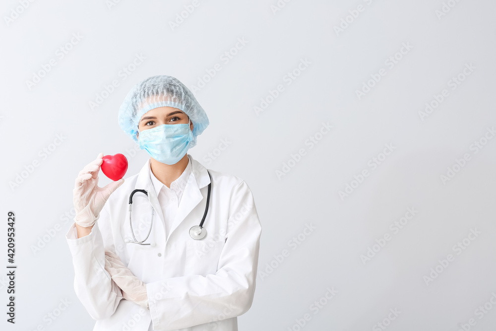 Cardiologist with red heart on light background Cardiologist with red heart on light background