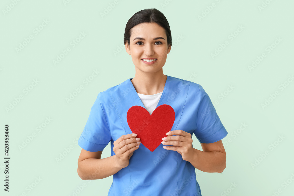 Cardiologist with red heart on color background Cardiologist with red heart on color background