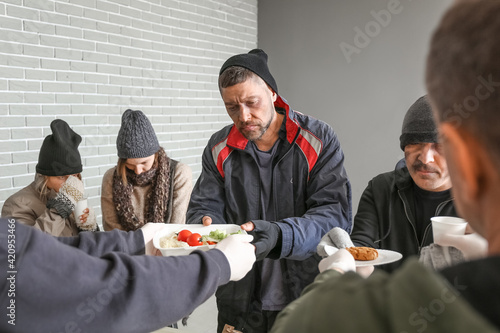 Volunteers giving food to h...
