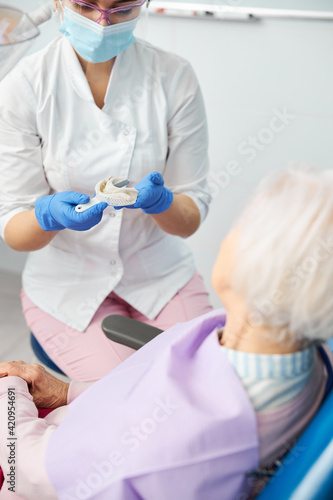 Female stomatologist is reviewing a dental impression