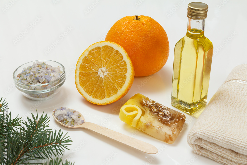 Cut orange with whole one, towel, bottle with aromatherapy oil and sea salt Cut orange with whole one, towel, bottle with aromatherapy oil and sea salt