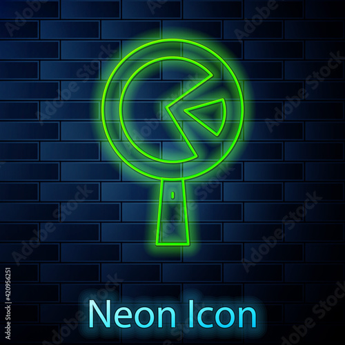 Glowing neon line Omelette in frying pan icon isolated on brick wall background. Omelet in a skillet. Vector