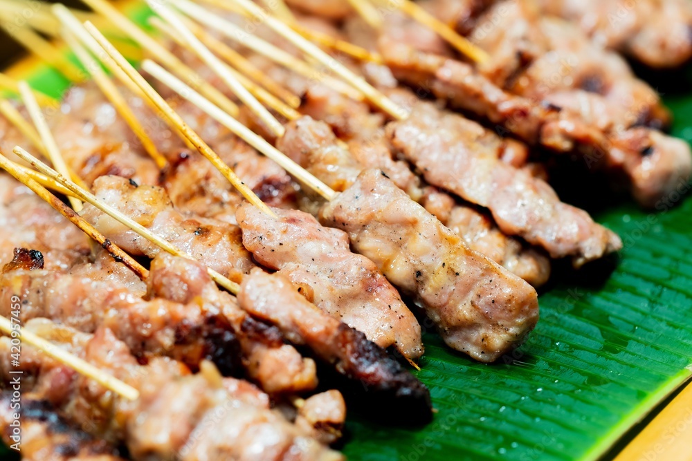 Close up of Moo ping, Slice pork skewer sticks grilled , thai street food market