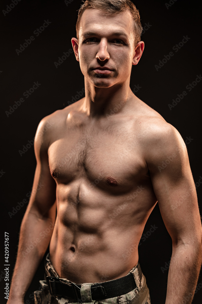 Fototapeta premium Studio shot of muscular topless military man on black background