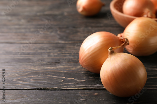 Ripe fresh onion on wooden background  space for text
