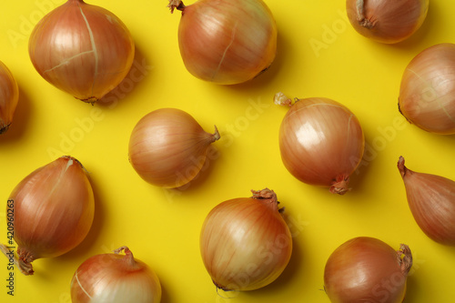 Flat lay with fresh ripe onion on yellow background
