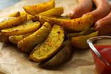 Tasty potato wedges, sauce and sausage, close up