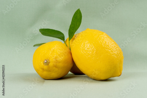 Lemon fruits on green background.