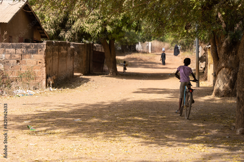 Fototapeta premium A girl riding a bicycle in rural The Gambia