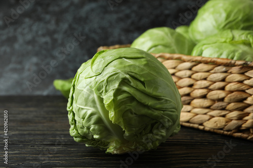 Basket with fresh cabbage on wooden table