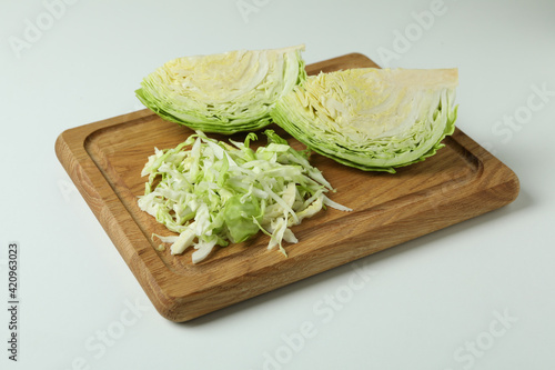 Board with fresh green cabbage on white background