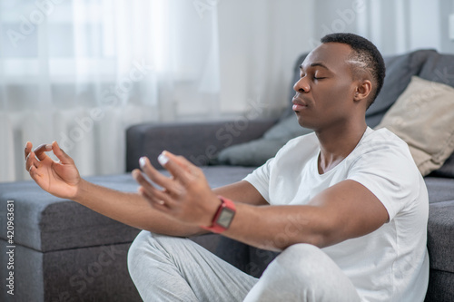 Obraz na plátne African american guy in white clothes meditating and looking peaceful